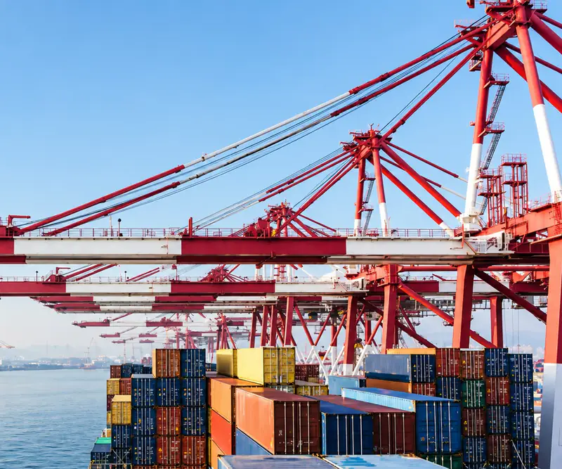 Container cranes over a loaded container ship in a port