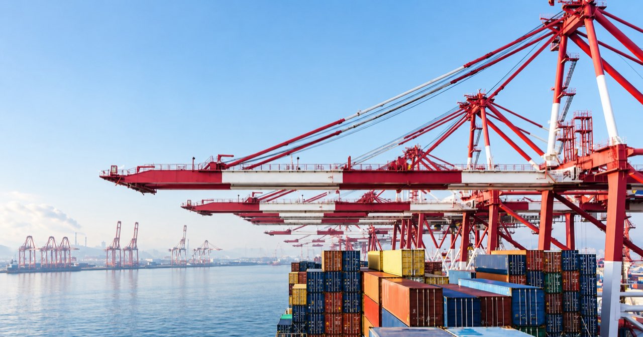 Red gantry cranes over a loaded container ship at a port