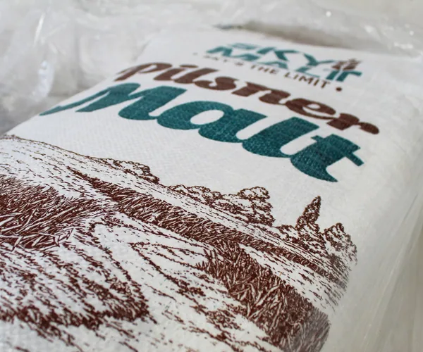Close-up of a woven SKY MALT Pilsner Malt bag, printed with the logo and a field illustration